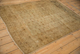 Angled view of a distressed Tabriz showing the turtle samovar border and low-pile texture.