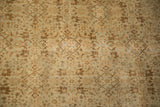 The distressed surface of an antique Tabriz rug, with a threadbare patch revealing the hand-knotted foundation.