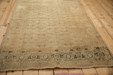 The worn, low pile and dark turtle samovar border of an antique Tabriz rug.