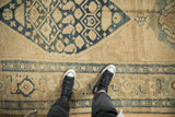 Textured low pile of a distressed Kurdish rug runner showing its geometric dusty blue and beige designs.