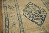 Low-pile texture of an antique Kurdish runner with its navy diamond medallion and geometric border.