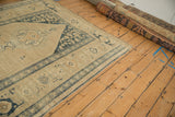 Distressed antique Kurdish runner with beige and dusty blue patterns viewed from a wide angle.