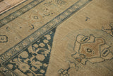 Angled view of the textured knot heads and dusty blue turtle samovar border on an antique Kurdish rug.