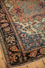 Intricate palmette and vine motifs in the navy border of an antique Farahan Sarouk square rug.