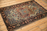 Perspective view of an antique Farahan Sarouk with a starburst medallion and meandering vine border.