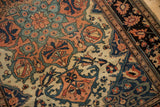 Detailed arabesques and floral patterns on the time-softened pile of an antique Farahan Sarouk.