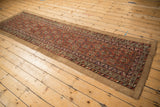Corner of an antique Persian Serab runner with brick red geometric patterns and camel selvage.