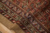 Antique Serab rug's folded edge with geometric borders in brick red, dusty blue, natural camel selvage.