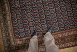 Antique Northwest Persian rug's repeating boteh pattern and unusual deep green main border.