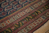 Antique Northwest Persian rug's unusual deep green border with geometric patterns and madder root red.