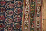 Northwest Persian antique rug detail showcasing unusual deep green border, navy field with botehs, and fringe.