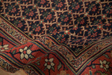 Dense, hand-knotted pile of an antique Bijar rug detailing the red vine border and navy lattice field.