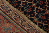 Detail view showing the antique Bijar rug's navy vine field, red border, and intact side cord.