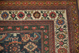 Corner detail of an antique Mahal rug showing its intricate Herati style borders in red, green, and blue.