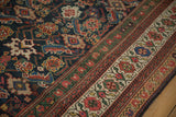 Angled view of the multi-banded border and Herati-patterned field on an antique Mahal carpet.