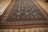 Angled view of an antique Mahal carpet highlighting its colorful Herati design and intricate borders.