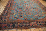 Close-up: Antique Mahal carpet's multi-tiered floral border, brick red, navy, sky blue field, and fringe.