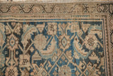 Distressed antique Hamadan carpet, geometric blue and sand patterns, with visible foundation.
