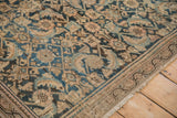 Distressed pile texture with stylized floral motifs in indigo blue and sand beige on Hamadan carpet.