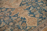Distressed antique Hamadan rug detail with low pile, showing geometric patterns in blue and beige.