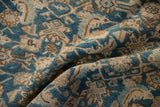 Textured close-up of distressed Hamadan carpet in indigo blue and sand geometric motifs.