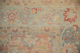 Distressed Tabriz carpet detail: dusty ruby red palmettes and blue vinery on abrashed ground.