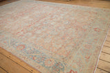 Textured pile of vintage distressed Tabriz rug, showing faded ruby red and powder blue Herati pattern.