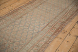 Distressed antique Bijar runner close-up with time-softened boteh patterns and muted vine borders.