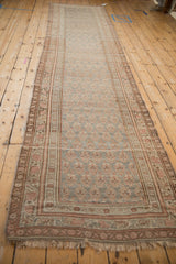 Distressed Antique Persian Bijar runner, showing muted boteh patterns and triple vine borders.