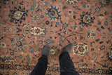 Detailed serrated palmettes and scrolling vinery on the antique Kerman carpet, dusty coral, navy.
