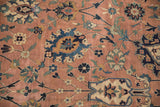 Antique Kerman carpet's dusty coral field with serrated navy palmettes and fine scrolling vinery.
