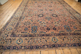 Antique Kerman carpet end, intricate navy border, dusty rose field, and palmette vinery.