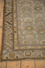 Distressed Kurdish Hamadan runner corner showing geometric border and worn Herati motif pile in olive, ivory, and faded blue.