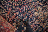 Intricate vinery and blossoms on a dark navy Mohajeran Sarouk rug, with red floral border.