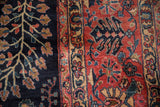 Vintage Mohajeran Sarouk with plush dark navy vinery and brick red floral motifs.