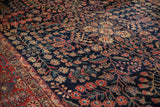 Vintage Mohajeran Sarouk carpet: dark navy floral vinery and brick red palmette border.