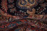Folded plush pile of vintage Mohajeran Sarouk rug, showing intricate floral vinery and palmettes.