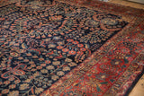 Intricate vinery and buds on dark navy field, brick red border, vintage Sarouk carpet.