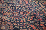 Intricate red blossoms, blue buds, and green vinery on dark navy Mohajeran Sarouk pile.