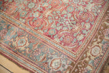 Corner of a distressed Bijar rug with its dusty teal samovar turtle border and ruby red field.