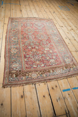 Angled view of a distressed Persian Bijar rug showcasing its allover Herati pattern and time-softened colors.