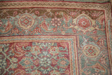 Corner detail of a distressed Bijar rug with a samovar turtle border and red Herati field.