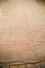 Distressed Oushak pile with faded floral motifs in dusty blush and silver.