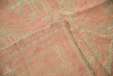 Distressed vintage Oushak carpet texture, faded blush pile, visible knot heads, restoration.
