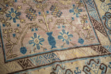 Vintage Distressed Khotan rug with mauve pile, blue vase motif, and saffron geometric vines.