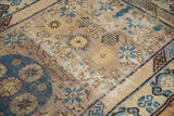 Vintage Khotan rug with significant pile wear, exposed foundation, and blue geometric patterns.