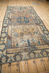 Distressed Uzbeki Khotan rug runner with geometric vines, cobalt blue motifs, and visible wear.