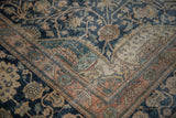 Detailed floral corner spandrel on an antique Kashan, showing the low, hand-knotted pile.