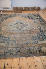 Angled view of an antique Mohtashem Kashan carpet showing its overall condition and time-softened patina.