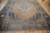 Antique Mohtashem Kashan carpet seen from an angle, displaying its time-worn texture and floral pattern.